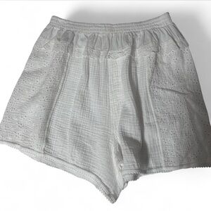 Free People white eyelet shorts with elastic waistband and pockets.